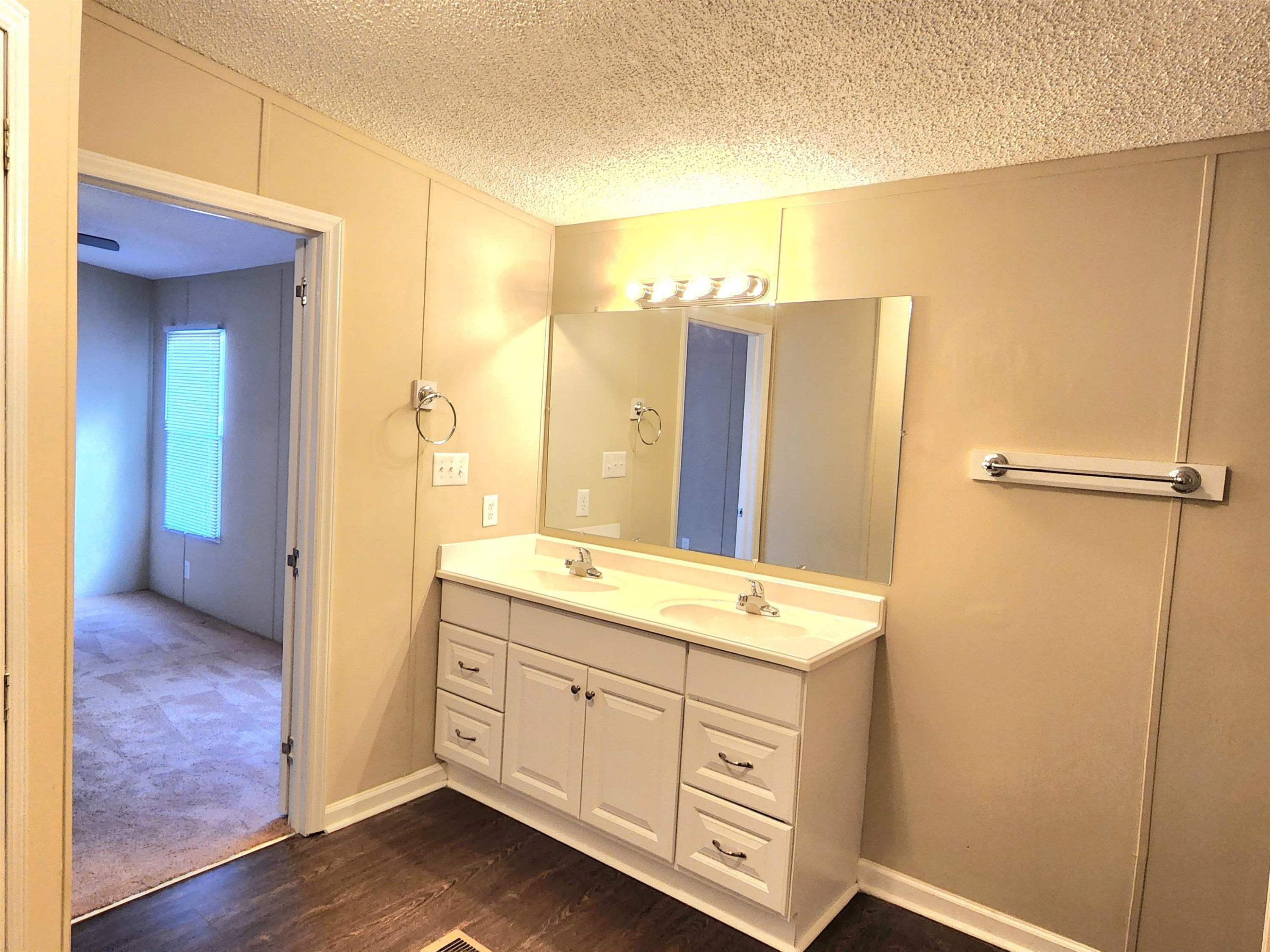 8333 Creek Road Willow Spring, NC 27592 - Photo 27 of 58 a bathroom with a sink a mirror and a shower