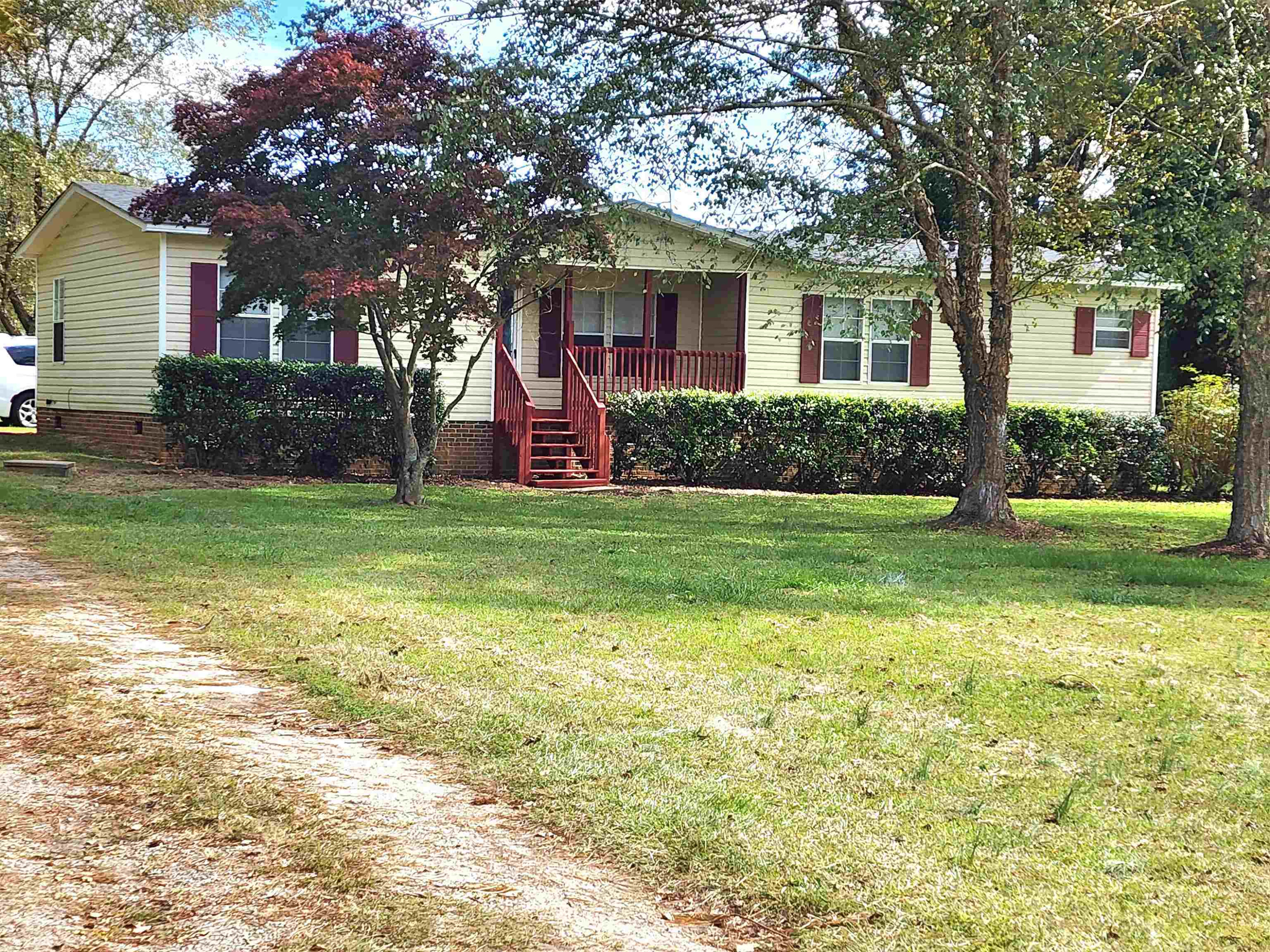 8333 Creek Road Willow Spring, NC 27592 - Photo 5 of 58 a view of a house next to a big yard and large trees