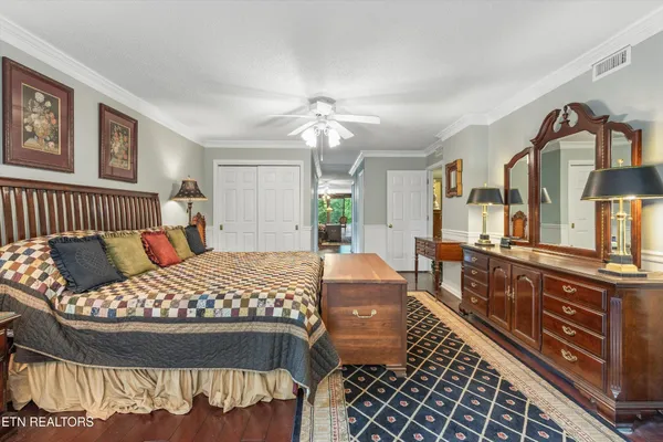 a bedroom with a bed and a dresser next to a window