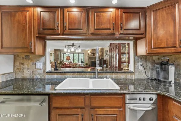 a kitchen with granite countertop a sink and a stove