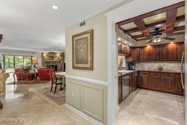 a kitchen with stainless steel appliances granite countertop a refrigerator a stove and a sink with couches