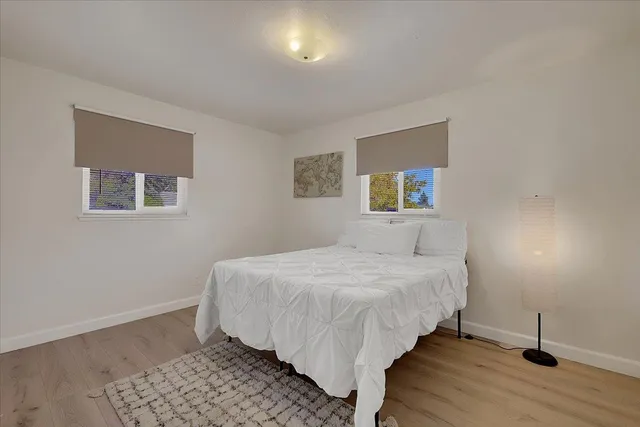 a bedroom with a bed and wooden floor