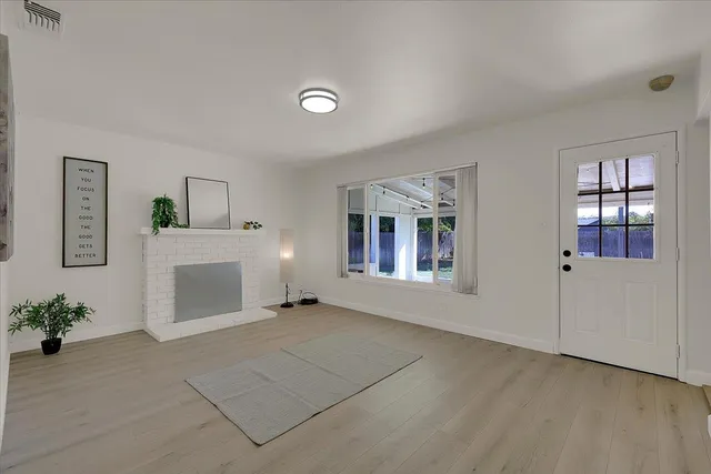 an empty room with windows and fireplace