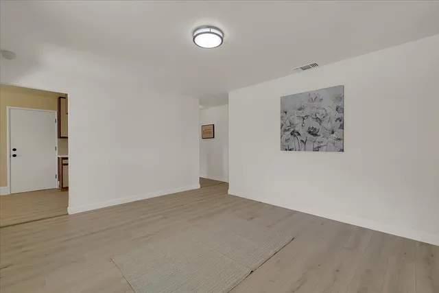an empty room with a painting on the wall