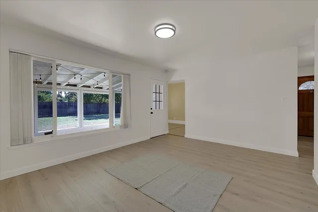 a view of an empty room with a fireplace and a window