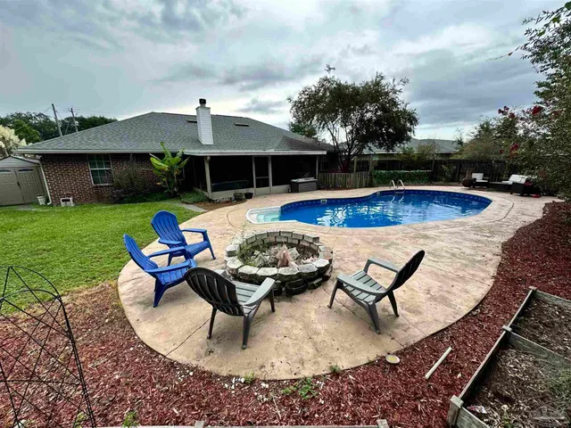 a swimming pool with outdoor seating and garden