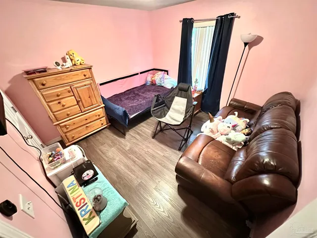 a bedroom with furniture and a large window