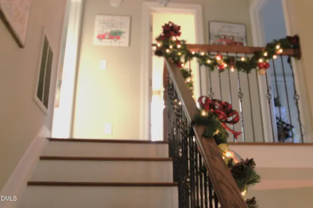 a view of a white house with large windows and a small yard