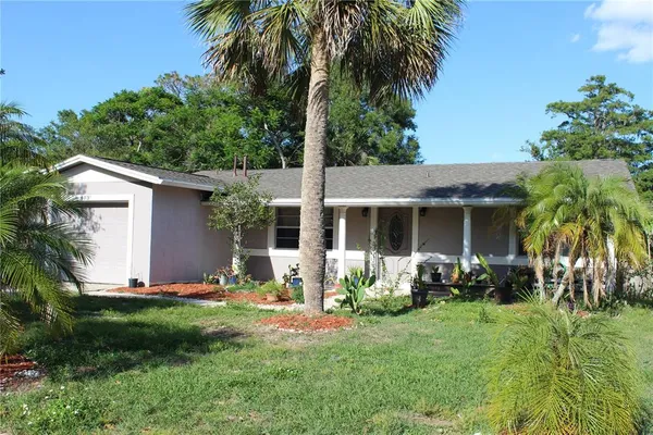 a view of a house with backyard sitting area and garden