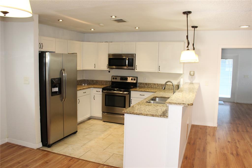 403 Murphy Road Winter Springs, FL 32708 - Photo 4 of 23 a kitchen with stainless steel appliances granite countertop a refrigerator a stove a sink and a wooden floors