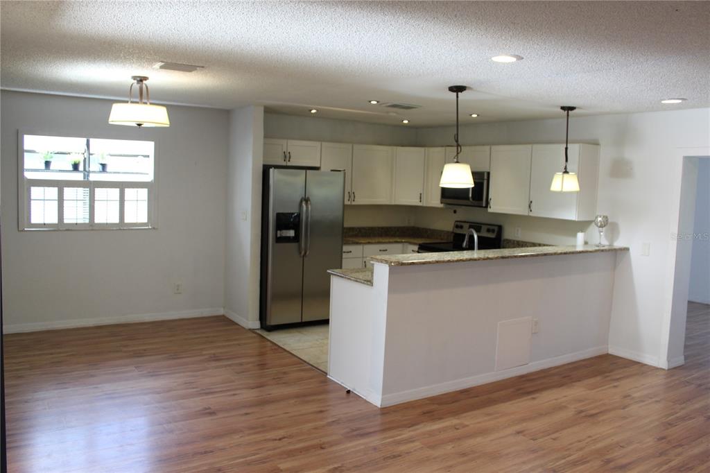 403 Murphy Road Winter Springs, FL 32708 - Photo 5 of 23 an open kitchen with a refrigerator and wooden floor