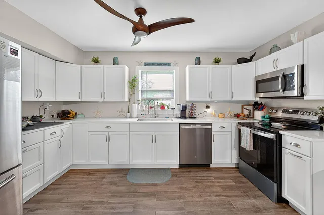 a kitchen with cabinets stainless steel appliances and a window