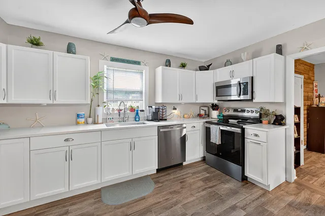 a kitchen with kitchen island granite countertop a sink cabinets and stainless steel appliances