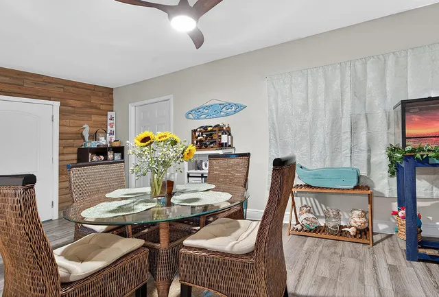 a dining room with furniture potted plants and wooden floor