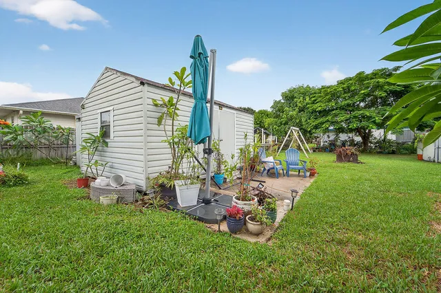 a view of a chair and table in backyard of the house