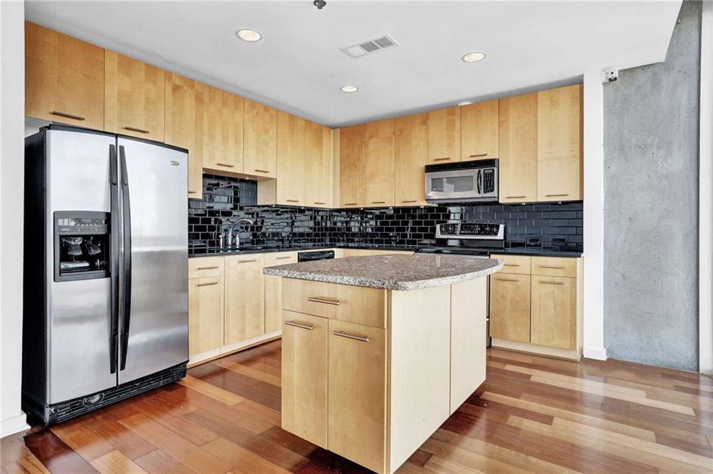 3324 Peachtree Road Northeast, Unit 2507 Atlanta, GA 30326 - Photo 6 of 25 a kitchen with stainless steel appliances a refrigerator stove microwave and sink
