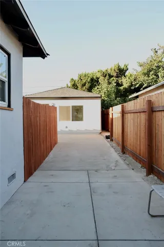 a view of backyard with small cabin and wooden fencing