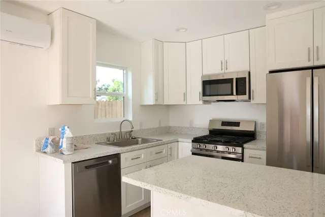 a kitchen with kitchen island a sink stainless steel appliances and cabinets