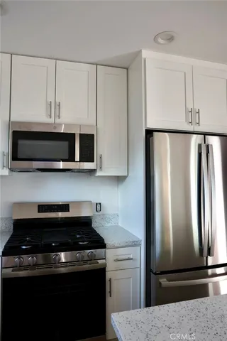a kitchen with white cabinets and stainless steel appliances