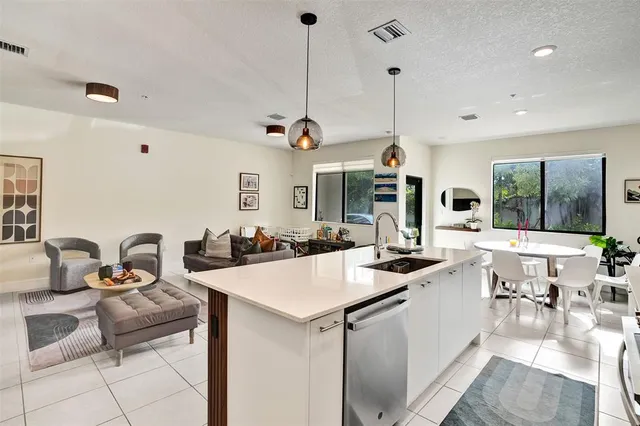 a kitchen with a stove a sink a dining table and chairs with wooden floor