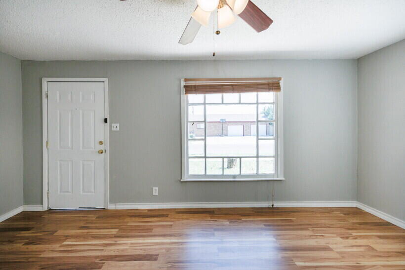 1110 46th Street Lubbock, TX 79412 - Photo 2 of 10 an empty room with wooden floor and windows