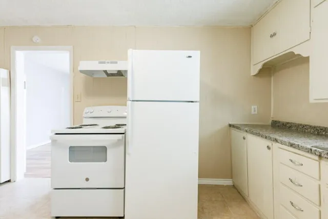 a white refrigerator freezer sitting inside of a kitchen