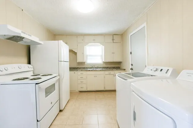 a kitchen with a stove top oven sink and cabinets