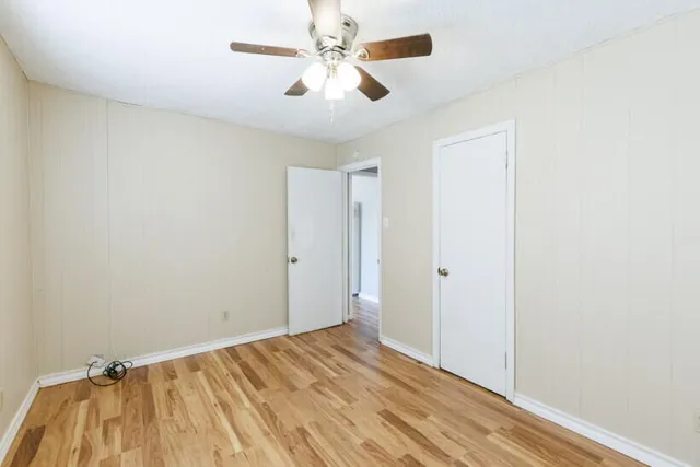 a view of a room with wooden floor and a ceiling fan