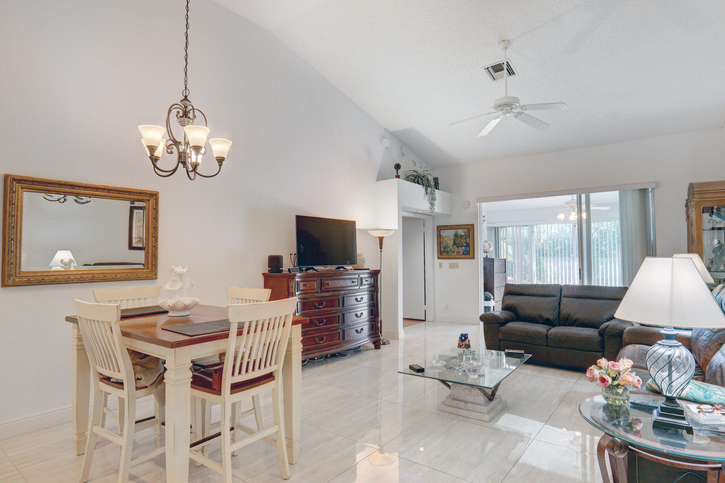 11110 Autoro Court Boca Raton, FL 33498 - Photo 9 of 24 a living room with furniture a chandelier and a flat screen tv
