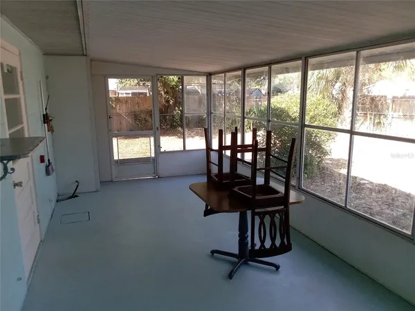 a view of a livingroom with furniture and floor to ceiling window