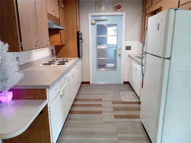 a kitchen with white cabinets and white appliances