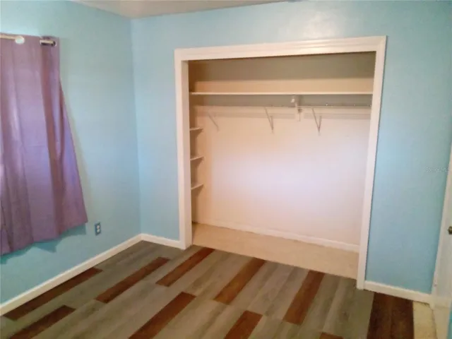 a view of a room with wooden floor and closet