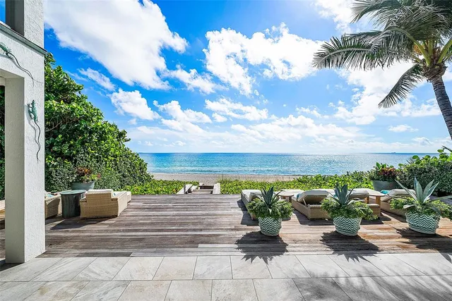 a view of backyard with seating space and trees in the background