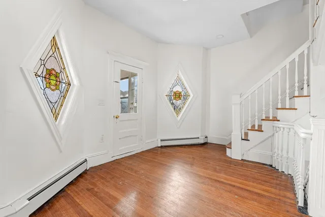 a view of an empty room with stairs and a window