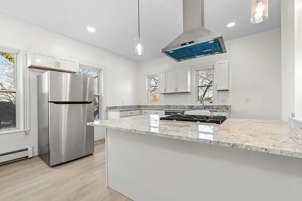 a kitchen with stainless steel appliances granite countertop a refrigerator a sink a stove a microwave and a refrigerator