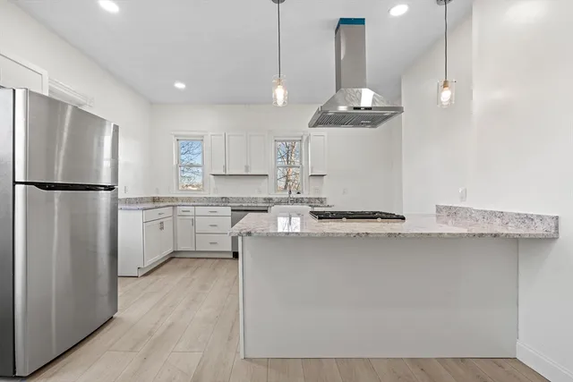 a kitchen with stainless steel appliances a refrigerator a sink dishwasher a stove and white cabinets with wooden floor