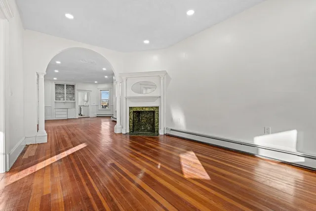 a view of a livingroom with wooden floor and a fireplace