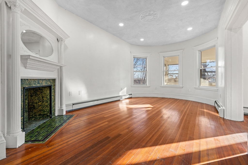 36 Elm Hill Park, Unit 1F Boston, MA 02121 - Photo 10 of 23 a view of empty room with wooden floor and fireplace