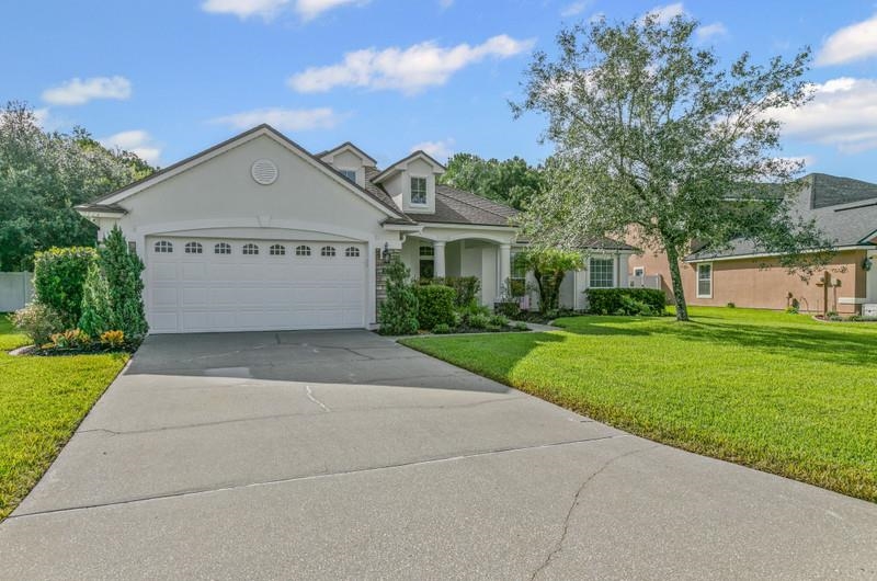 2724 North Portofino Road St. Augustine, FL 32092 - Photo 2 of 86 View of front of property with stucco siding, a front yard, a garage, and driveway