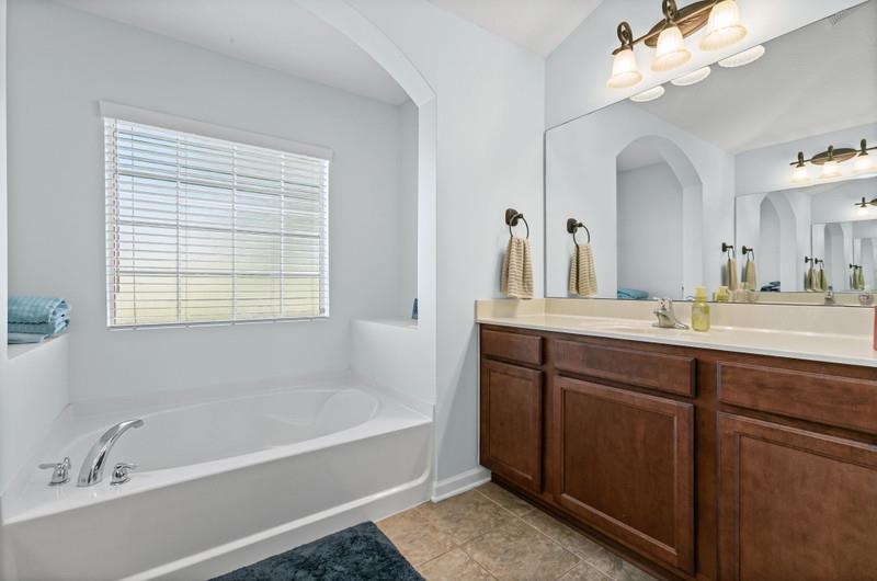 2724 North Portofino Road St. Augustine, FL 32092 - Photo 27 of 86 a bathroom with a tub a sink and mirror