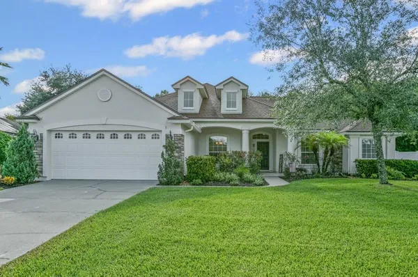 a front view of a house with a yard and trees