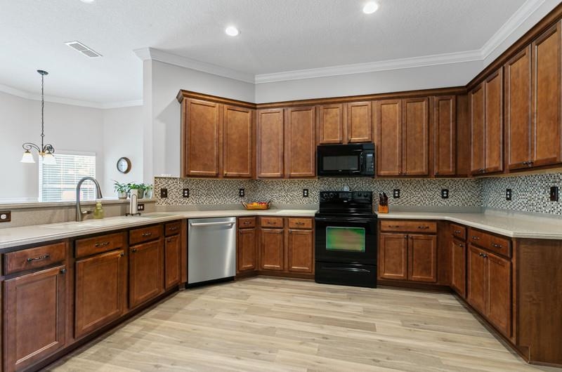 2724 North Portofino Road St. Augustine, FL 32092 - Photo 34 of 86 a kitchen with granite countertop a stove top oven sink and cabinets