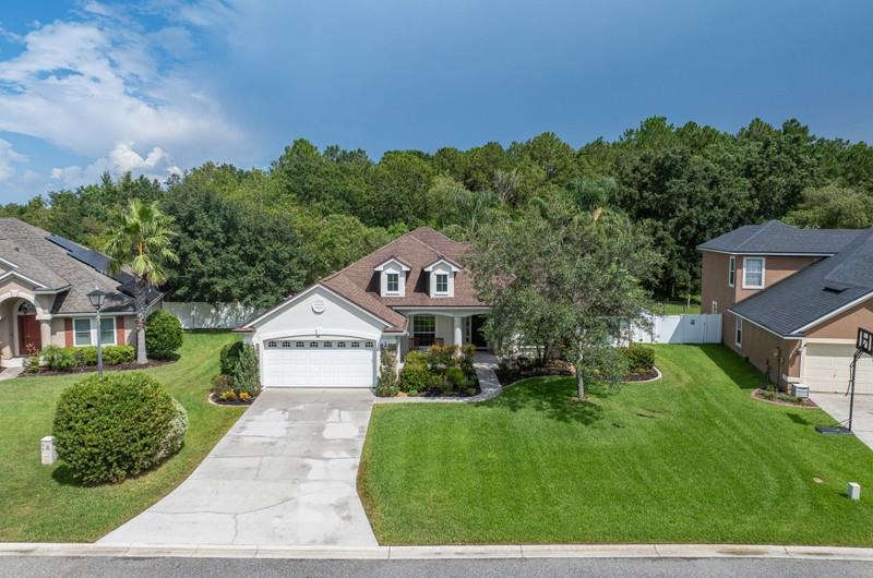 2724 North Portofino Road St. Augustine, FL 32092 - Photo 80 of 86 a view of a house with a small yard and a large tree