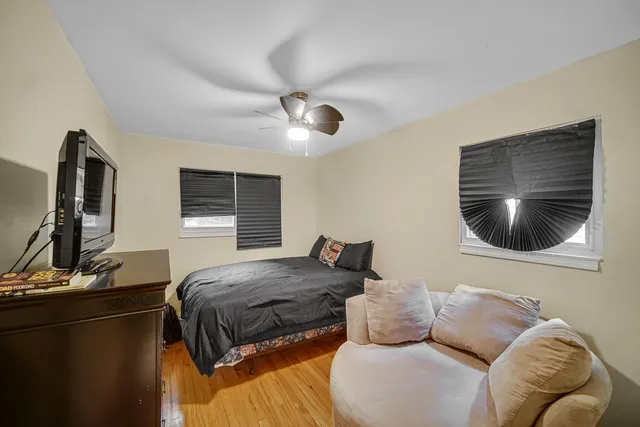 a bedroom with a bed and wooden floor
