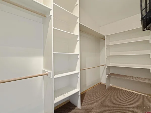 a view of walk in closet with empty racks