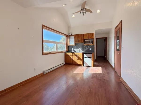 an empty room with wooden floor and windows