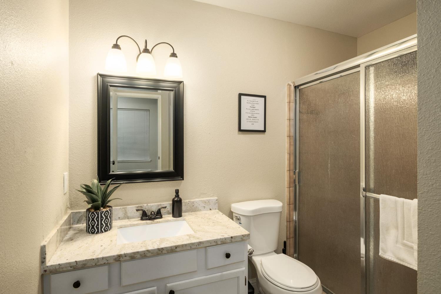 2811 East Westfall Road Mariposa, CA 95338 - Photo 10 of 25 a bathroom with a granite countertop toilet sink and mirror