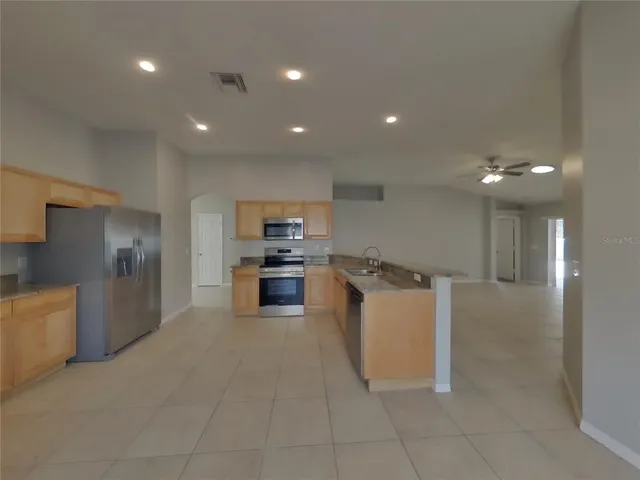 a kitchen with a refrigerator and chairs