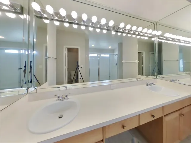 a bathroom with a sink a large mirror and a mirror