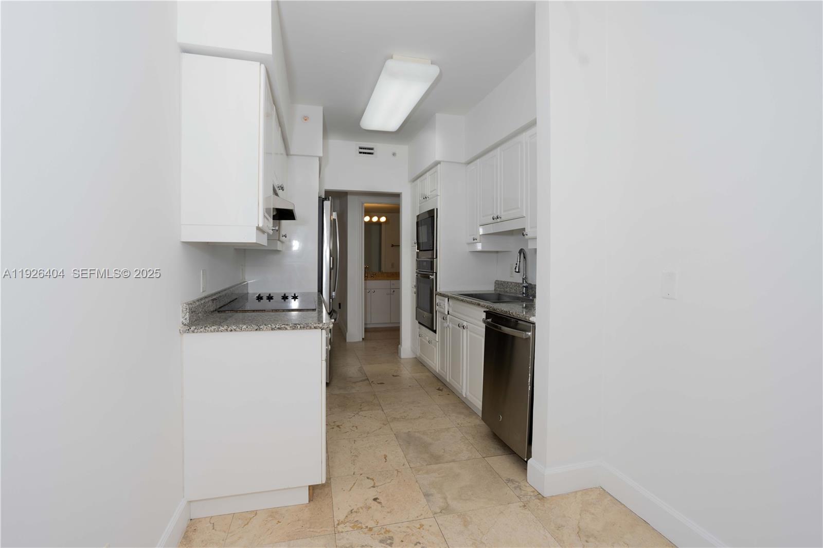4779 Collins Avenue, Unit 504 Miami Beach, FL 33140 - Photo 11 of 45 a kitchen with a refrigerator a stove top oven and a dishwasher